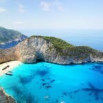 Stunning aerial view of Navagio Beach in Zakynthos, Greece, featuring turquoise water and a sunken ship.