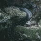 Dramatic aerial shot of a winding road through a gorge in England, showcasing rocky landscapes.